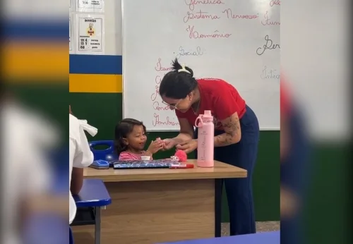 Professora segura filha de aluna durante aula para que mãe não perca conteúdo